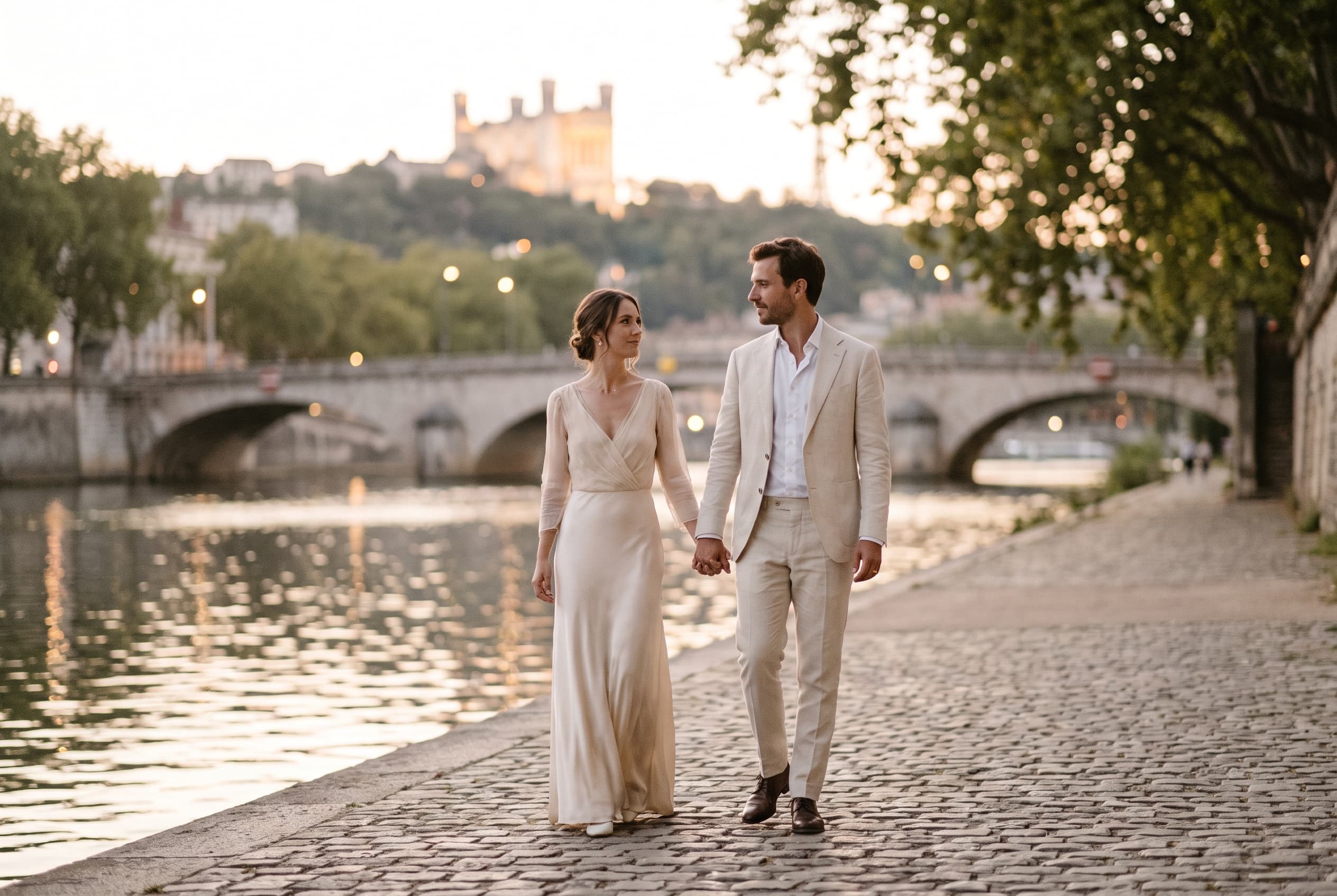 Couple de mariés sur les quais de Saône à Lyon, la basilique de Fourvière en arrière-plan — galerie photo mariage à Lyon